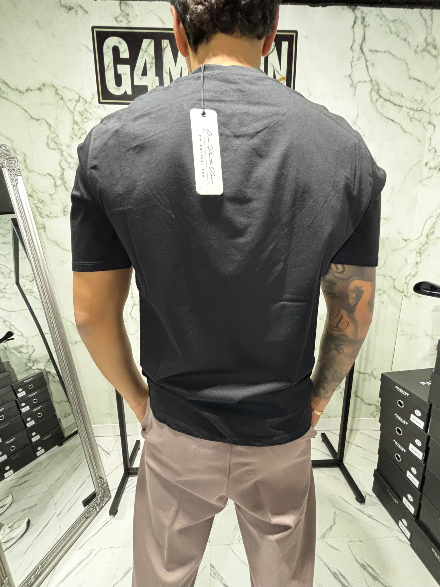 Back view of a man wearing the Shirt 2.0 Filo di Scozia Essential Fit by G4 Maison in a store setting.