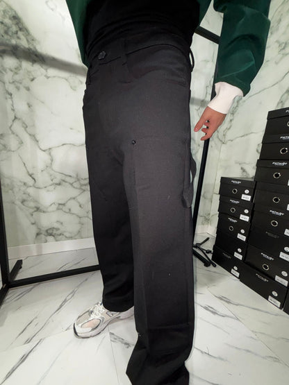 Person wearing Cargo 2.0 Tech Baggy pants with sneakers, demonstrating modern and comfortable baggy fit in a minimalist setting.