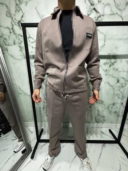Coordinato 2.0 Essential Zip Beige, featuring a full zip jacket with structured collar and matching pants, styled with sneakers.