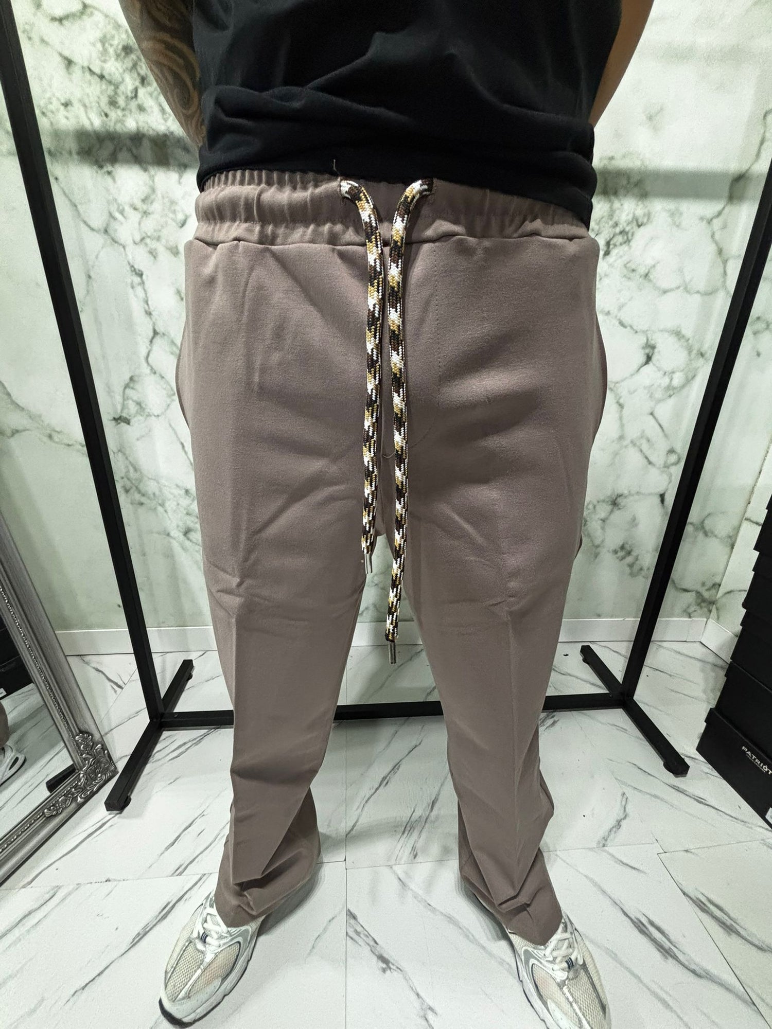 Close-up of Coordinato 2.0 Essential Zip Beige pants with technical drawstring and sleek design.