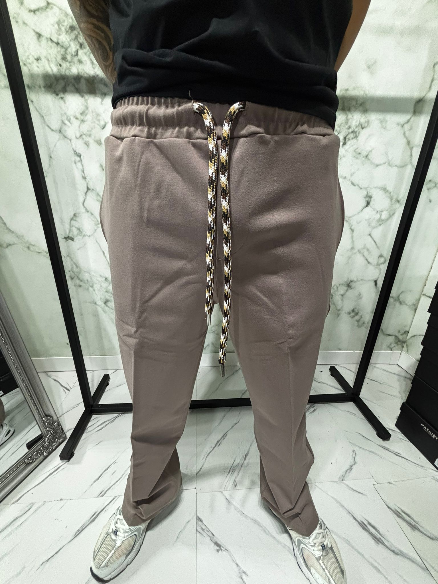 Close-up of Coordinato 2.0 Essential Zip Beige pants with technical drawstring and sleek design.