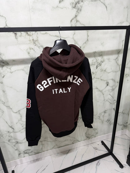 Felpa G2 Firenze “Double Chocolate” con design bicolore, patch numero 2, logo G2 FIRENZE ITALY, appesa in showroom.