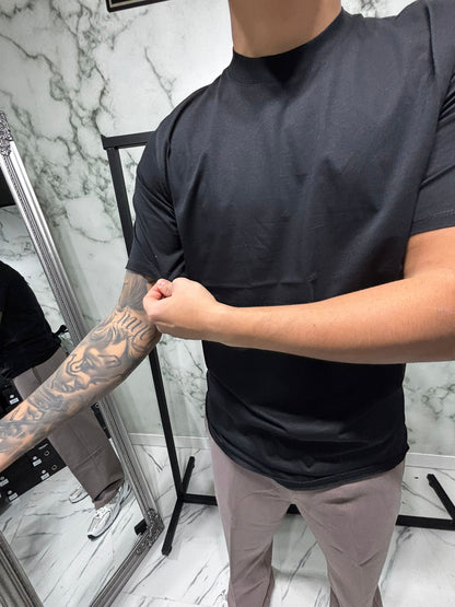 Man wearing black Shirt 2.0 Filo di Scozia Essential Fit, highlighting smooth fit and luxury texture in modern setting.